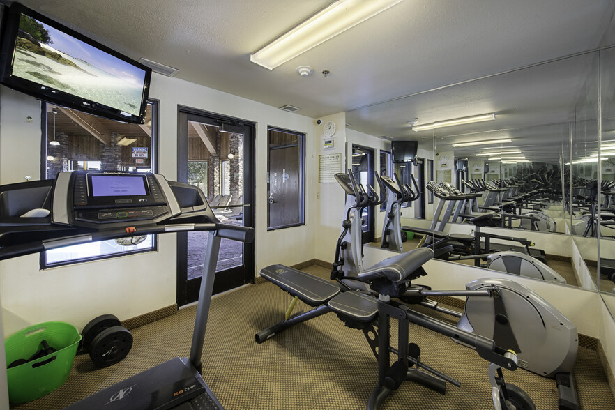 Fitness room with treadmill, ellipticals, and weights