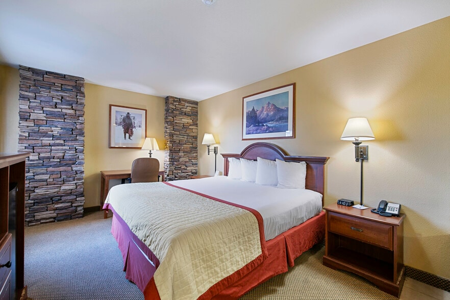 Deluxe King room with stone column accents and Western art